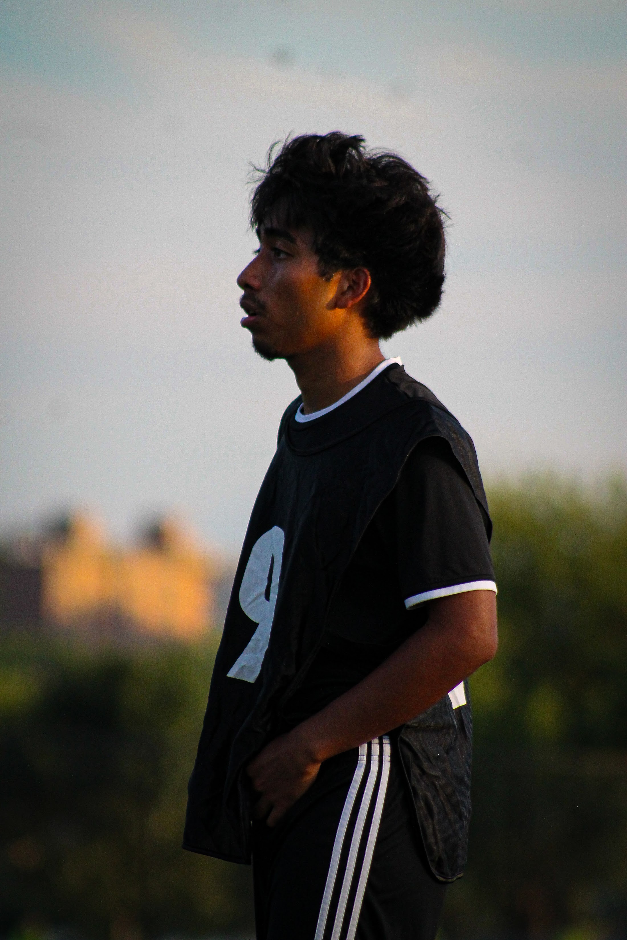 Side-profile portrait of a player wearing a black number nine bib