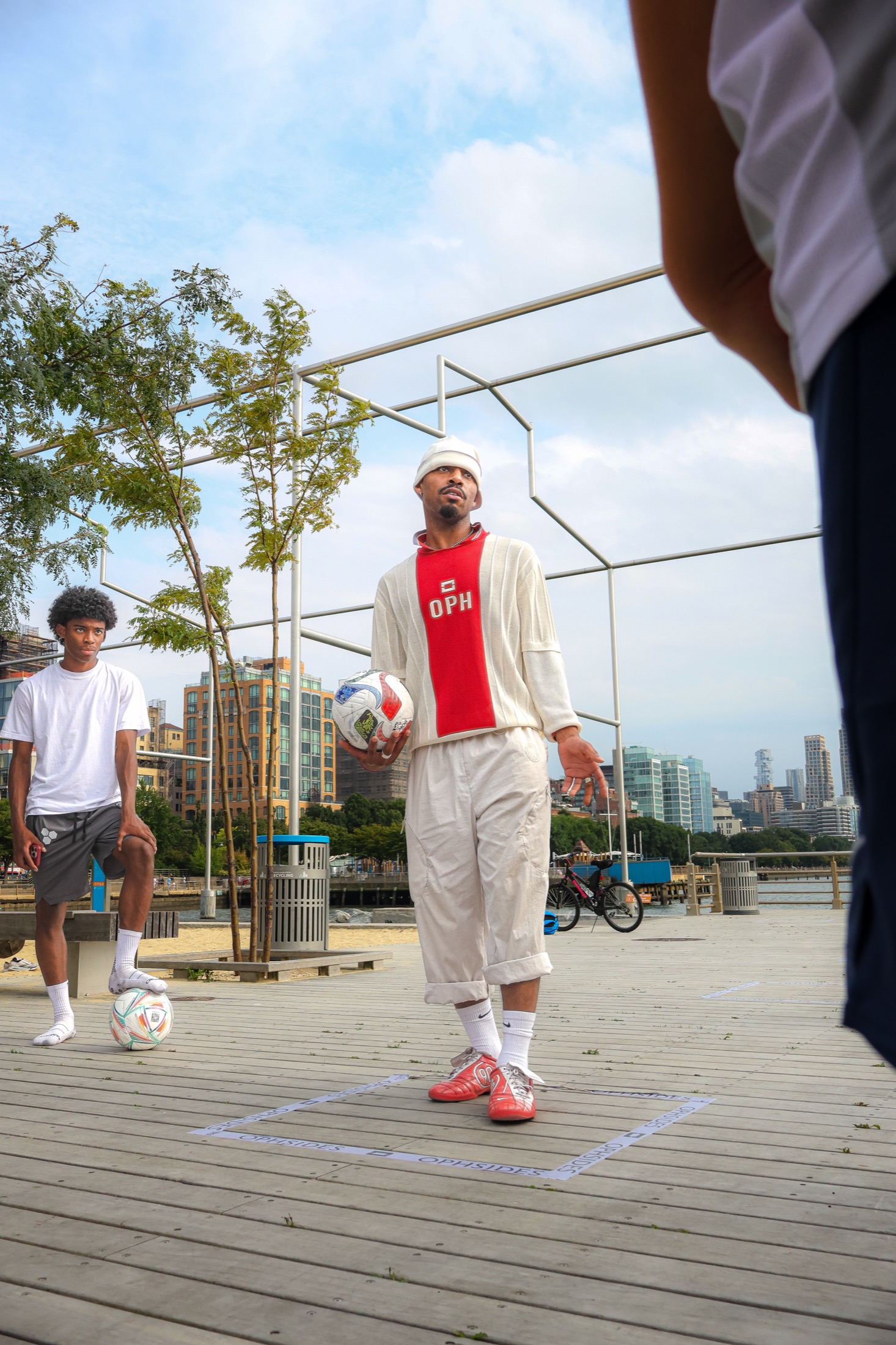 Ophsides organizer holding a soccer ball on the waterfront