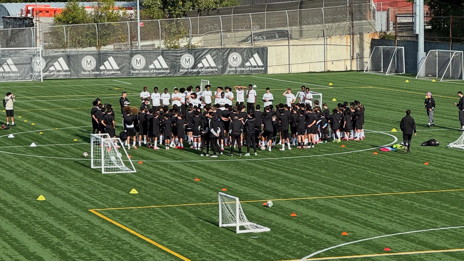 Players gathered in a large huddle on the Met Oval field at the October 12 Showcase